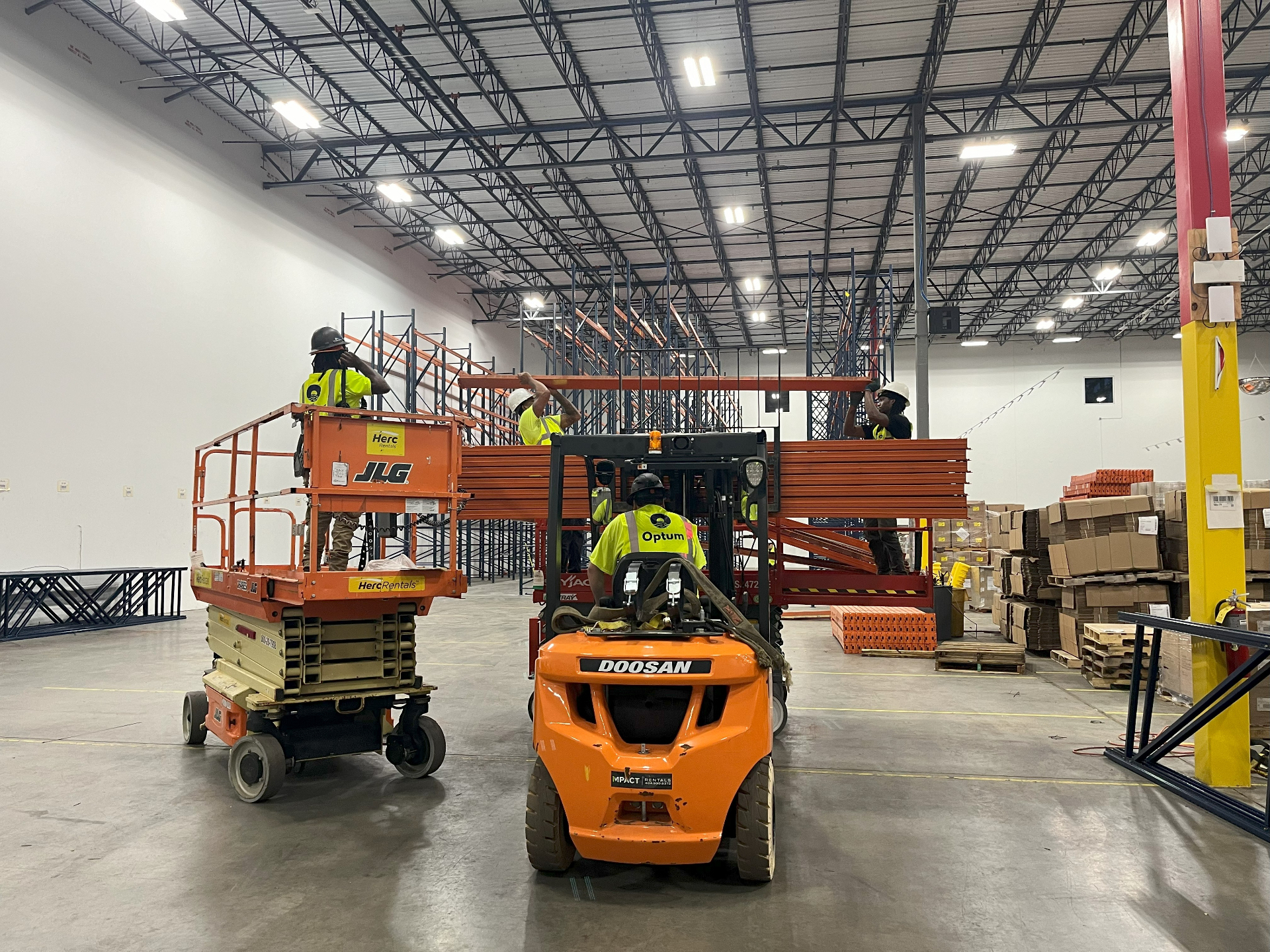 Optum team installing warehouse racking with forklift and scissor lift