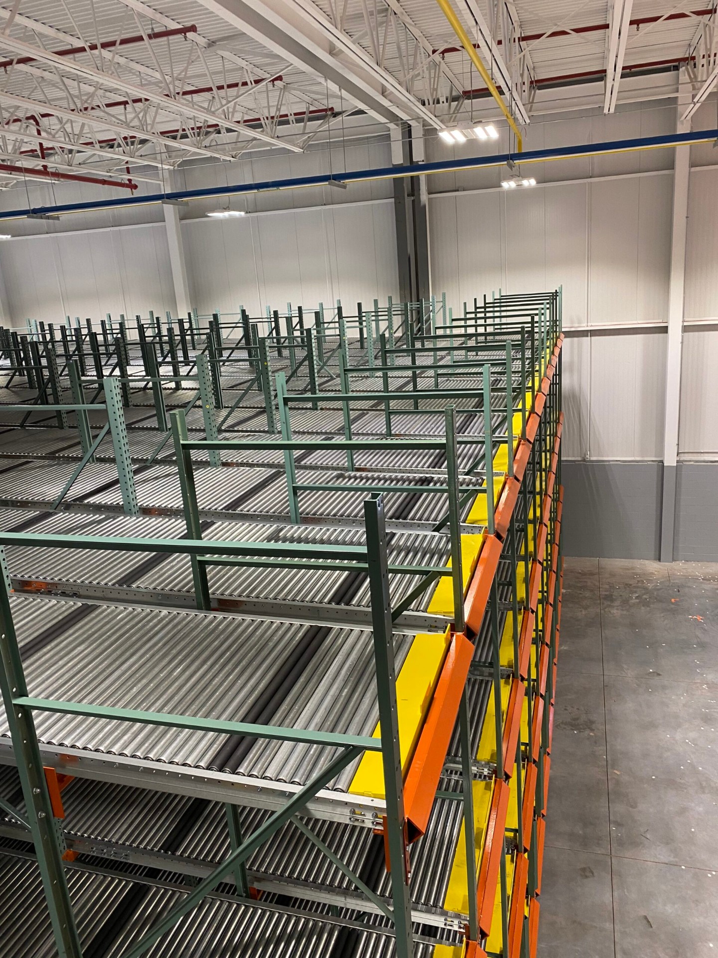 Pallet flow racking system with green frames and roller lanes