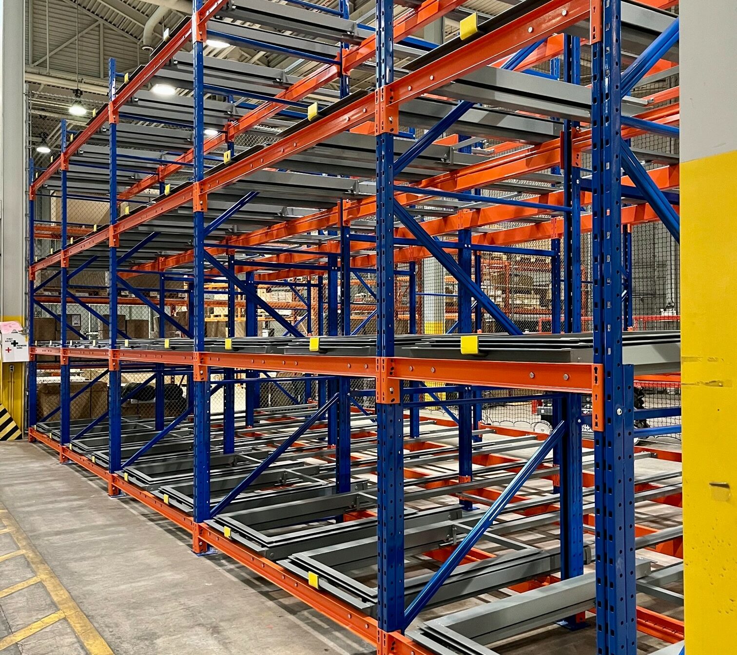 Pushback racking system with blue frames and orange beams